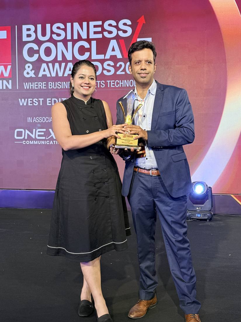 Sanil Nadkarni holding the ETNOW Best Emerging Startup trophy on stage
